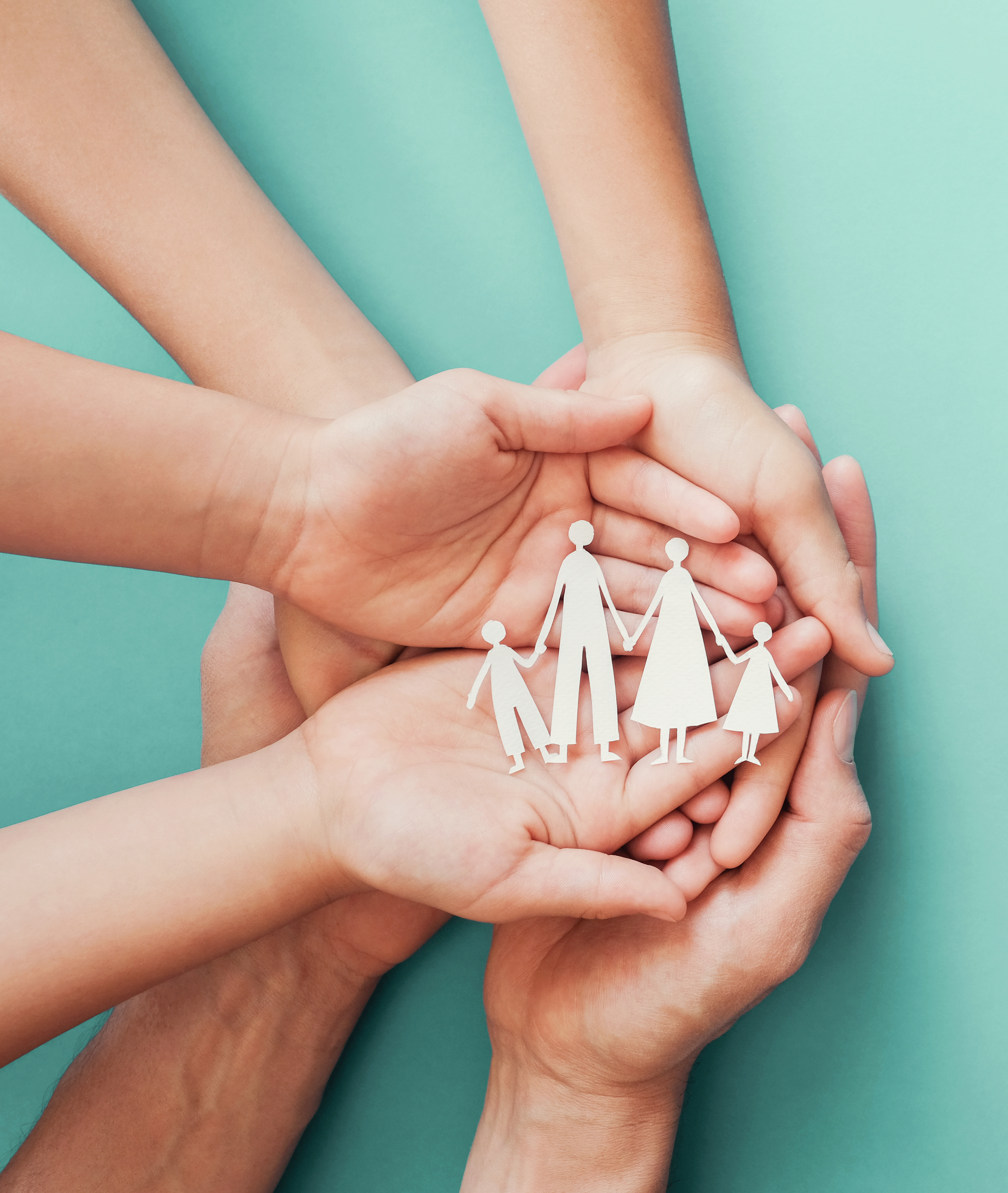 Adult and children hands holding paper family cutout, family hom adult and children hands holding paper family cutout
