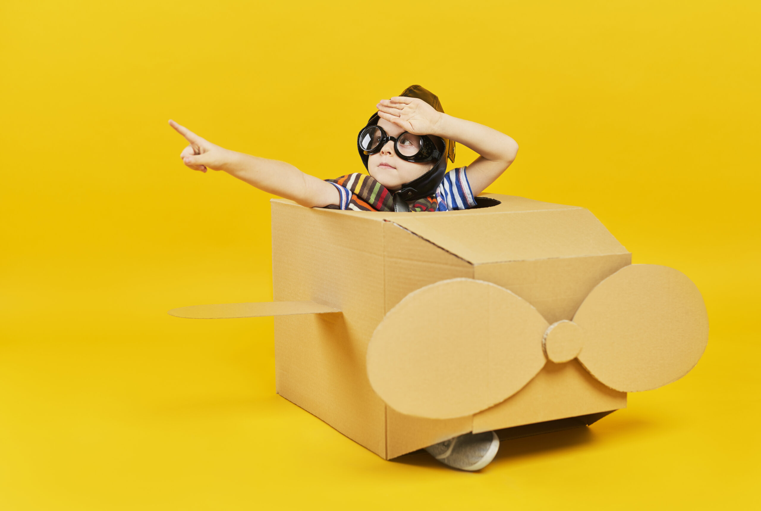 Child as astronaut in toy plane pointing at copy space child as astronaut in toy plane pointing scaled